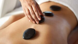 A visitor receives stone massage therapy.